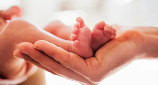 mom holding babies feet